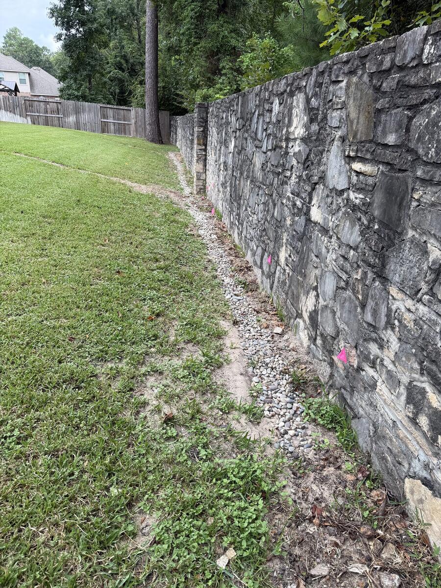 Drainage improvement beside a stone retaining wall